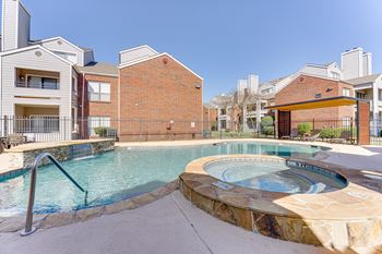 A swimming pool with a hot tub in the middle of it.